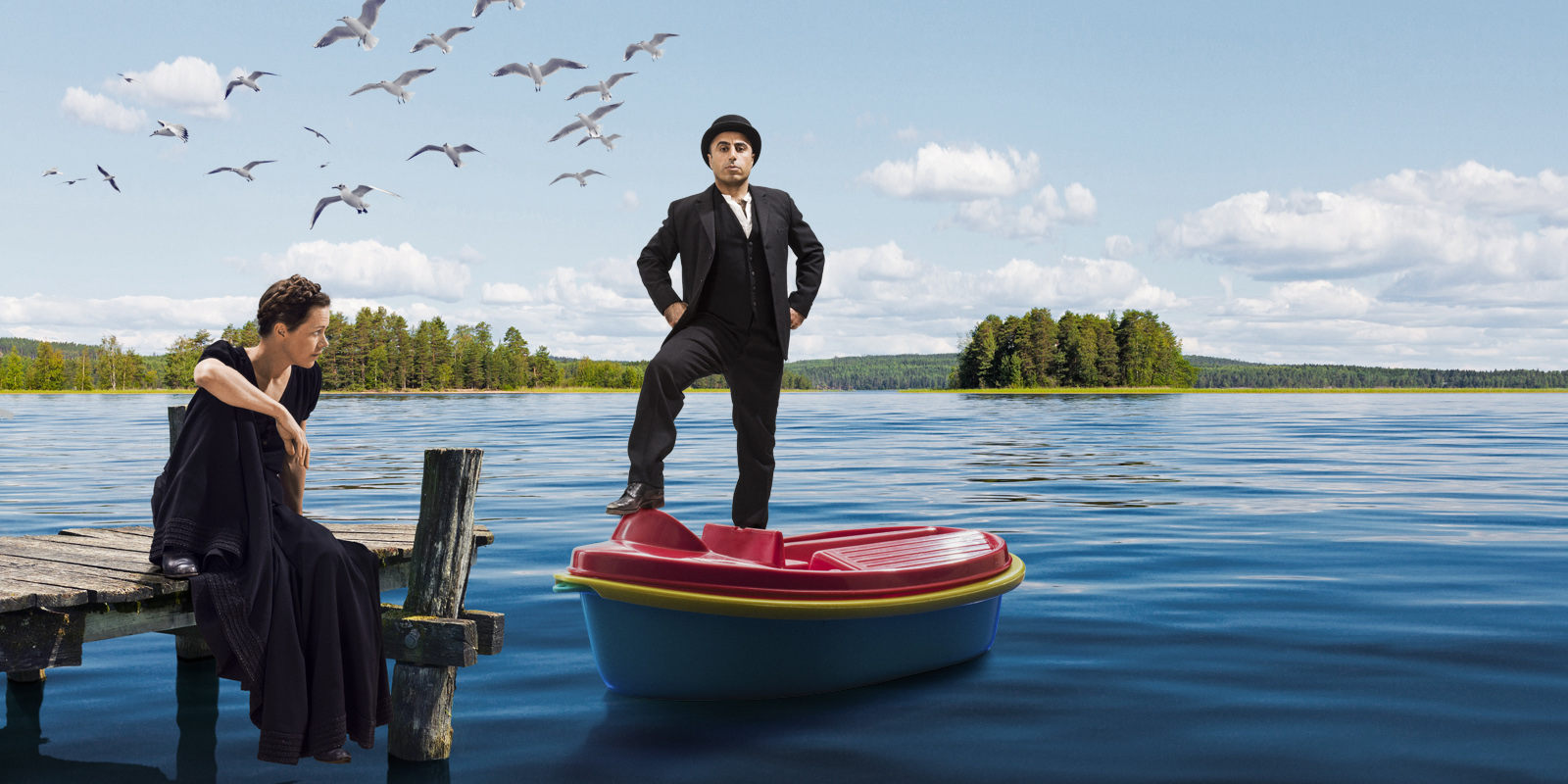 Kampanjbild Hemsöborna: på bilden ses Mia Höglund-Melin sittande på en brygga och Özz Nûjen stående i en leksaksbåt ute på sjön en glittrande sommardag