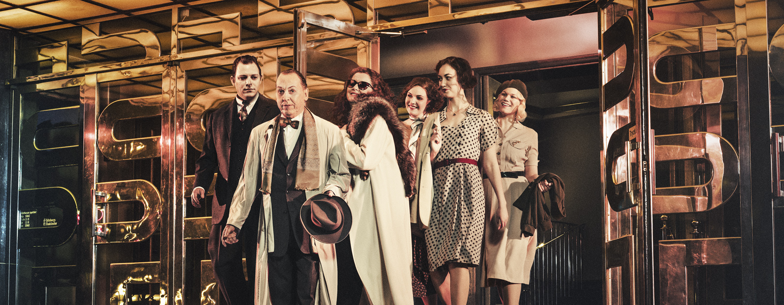 Kampanjbild Karl Gerhard. På bilden ses Eric Ericson, Tomas von Brömssen, Carina M Johansson, Carin Juborg, Vinga Magnusdotter, Märta Fransson. De kliver ut från huvudentrén till Göteborgs Stadsteater.