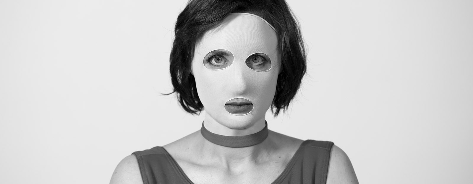 Karin de Frumerie med en tygmask för ansiktet, vilken täcker allt utom ögonen och munnen..